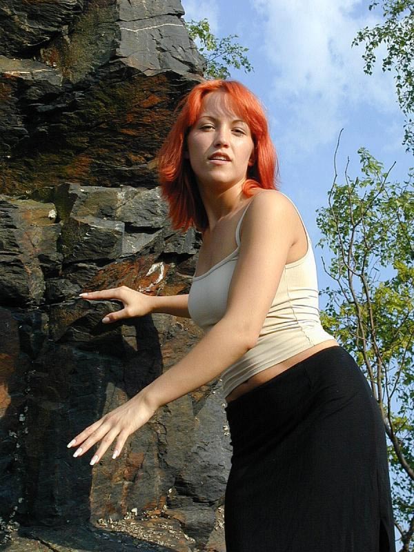 rothaariges Girl an draußen an einem Felsen